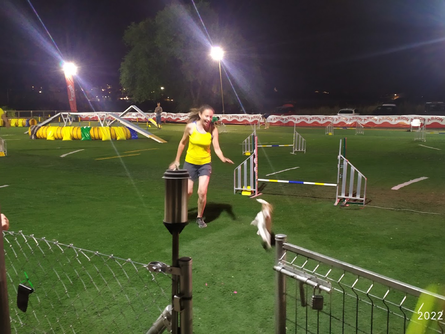 Guía y su perro compitiendo de noche en una prueba de Agility en Dogquijote