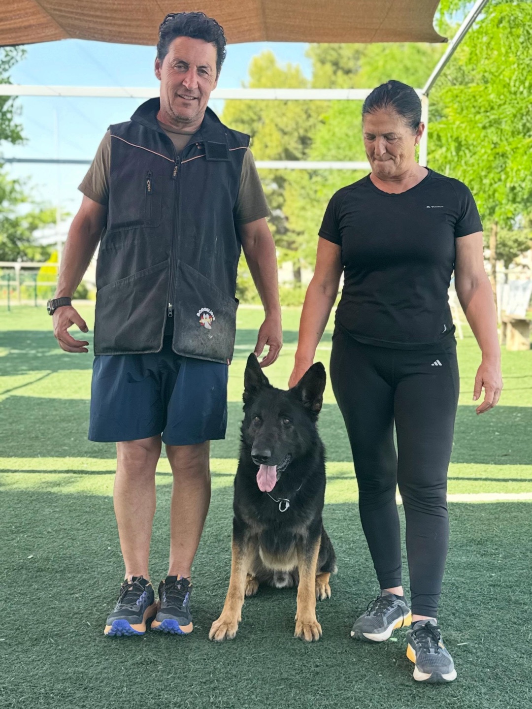 Pareja posando con su pastor alemán tras el adiestramiento en Dogquijote
